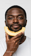 Portrait of a Cheerful Man Holding a Melon Slice with a Bright Smile