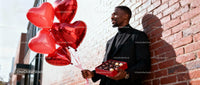 Man Holding Heart Balloons and Chocolates on Valentines Day