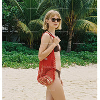 Young Woman in Bikini with Red Mesh Bag on Tropical Beach