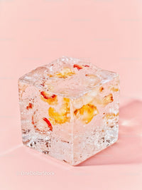 Close-up of Clear Ice Cube with Fruit Pieces Inside