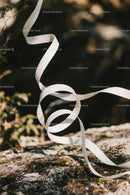 Close-up of White Plastic Ribbon Waste on Sandy Beach