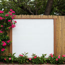 Blank white wooden board surrounded by blooming pink flowers