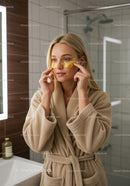 Young Woman Relaxing with Eye Patches in Modern Bathroom