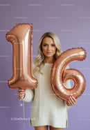 Young woman celebrating sixteenth birthday with balloons