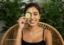 Young Woman in Black Tank Top Applying Facial Mask with Cucumber on Forehead
