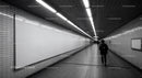 Underground subway tunnel with fluorescent lighting and tiled walls