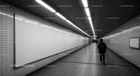 Underground subway tunnel with fluorescent lighting and tiled walls