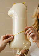 Woman Preparing Gold Number One Balloon for Celebration
