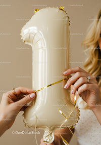 Woman Preparing Gold Number One Balloon for Celebration