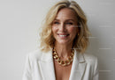 Elegant Blonde Woman in White Blazer Wearing Gold Chain Necklace