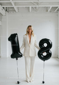 Elegant woman celebrating eighteenth birthday in white suit