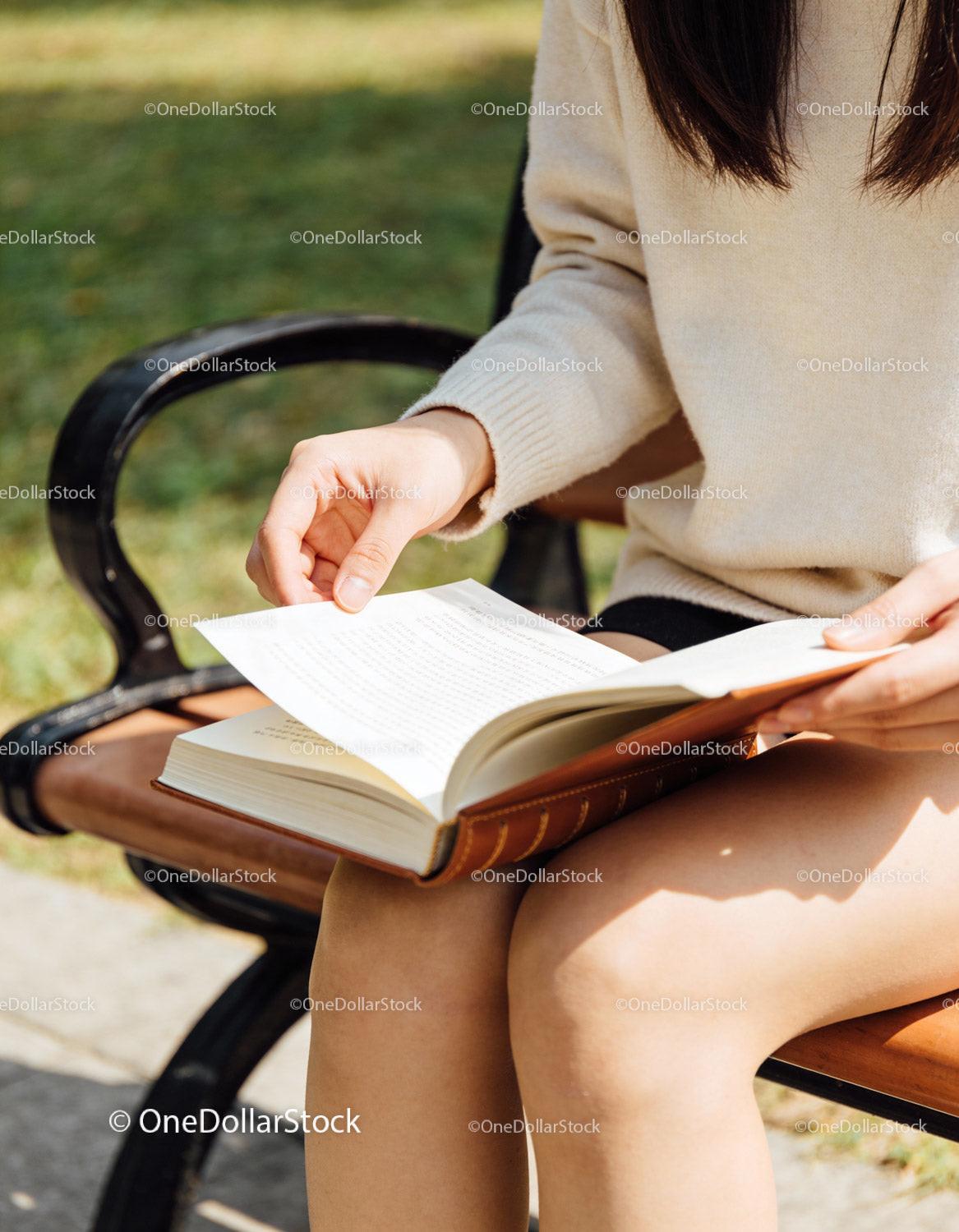 Person Reading Book Outdoors on a Sunny Day