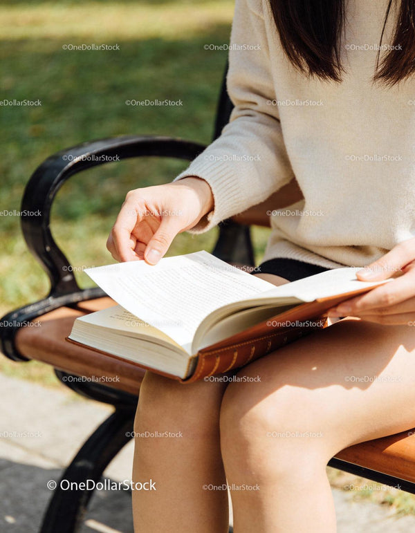 Person Reading Book Outdoors on a Sunny Day