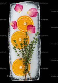 Fresh Orange Slices and Herbs Frozen in Ice Block