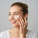 Young Woman Applying Moisturizer with Bright Clear Skin in Studio