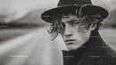 Young Man in Stylish Raincoat with Wet Look in Overcast Outdoor Scene