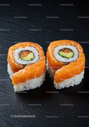 Fresh salmon sushi rolls with avocado on black slate