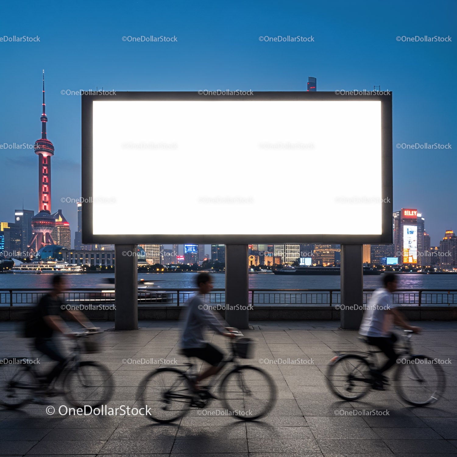Evening cyclists passing large empty billboard by city river