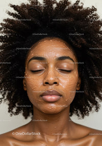 Young Woman with Curly Hair Applying Facial Mask for Skin Rejuvenation