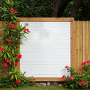 Empty white wooden board surrounded by vibrant red flowers