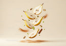 Fresh pear halves with cinnamon and pistachios floating on beige