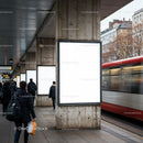 Commuters walking past blank urban advertisement panels