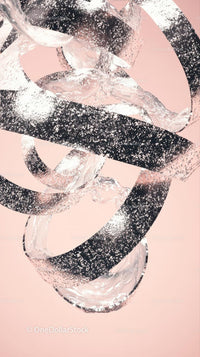 Elegant Black and Clear Glass Rings Art with Light Pink Background
