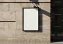 Blank poster frame on textured urban stone wall