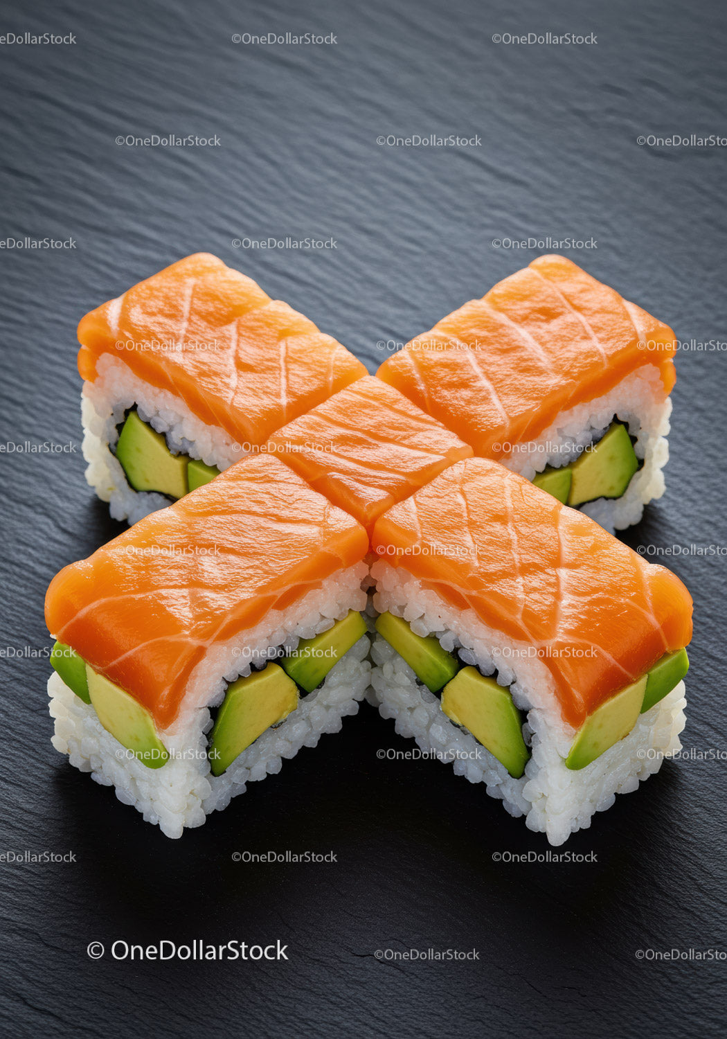 Świeże rolki sushi z łososiem i awokado na powierzchni łupkowej