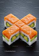 Fresh salmon avocado sushi rolls on slate surface