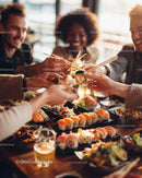 Diverse group of friends enjoying colorful sushi in modern restaurant