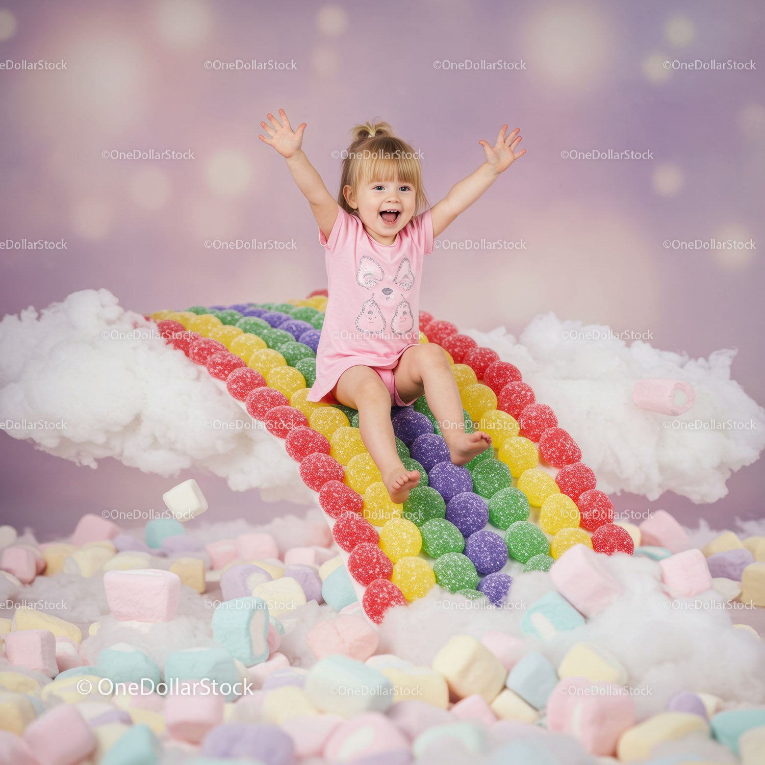 Joyful toddler sliding down colorful candy rainbow