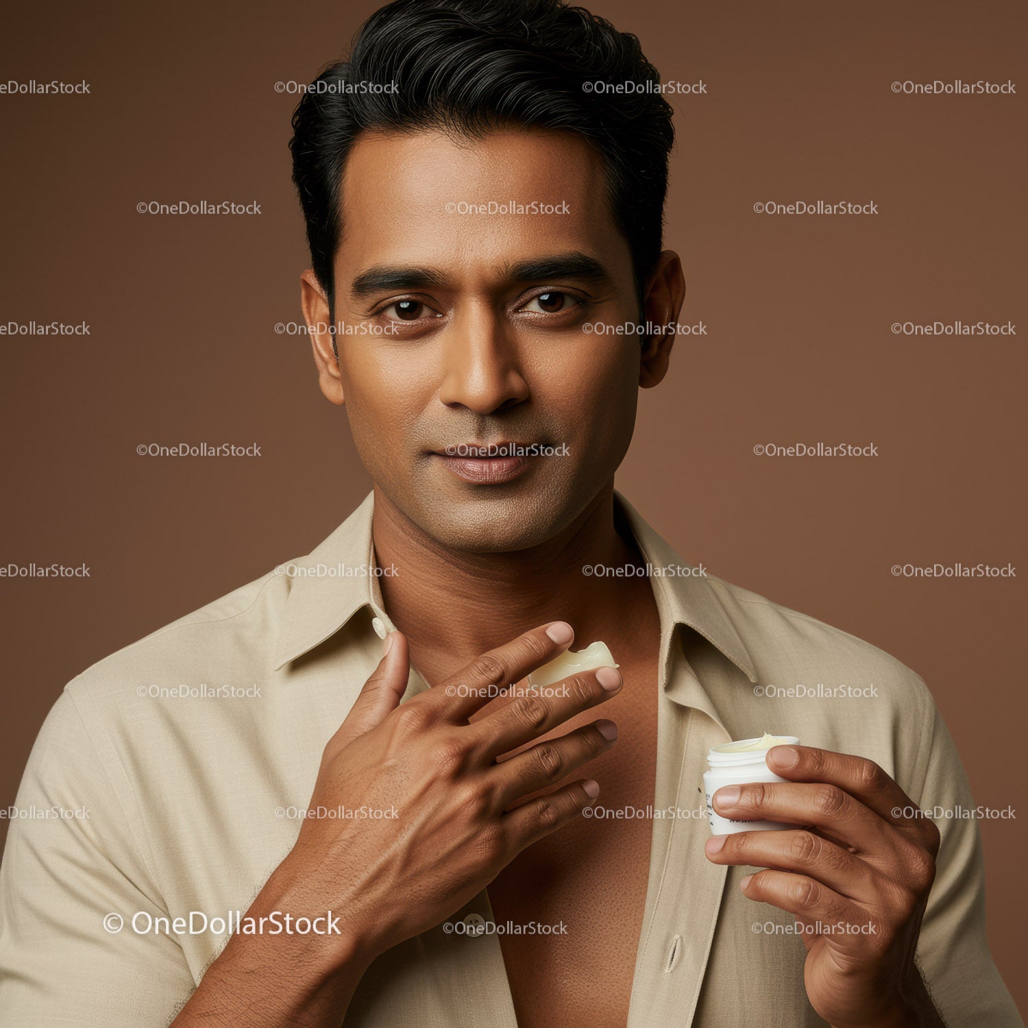 Elegant Man Applying Moisturizer with Calm Expression for Skincare