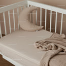 Cozy baby crib with crescent moon pillow and soft blanket