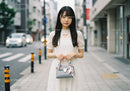 Young Woman in White Lace Dress Walking in a City Street