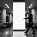 Blurred businessman walking past bright blank billboard indoors