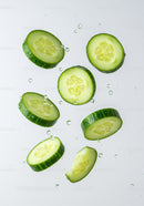 Fresh cucumber slices suspended in clear water droplets