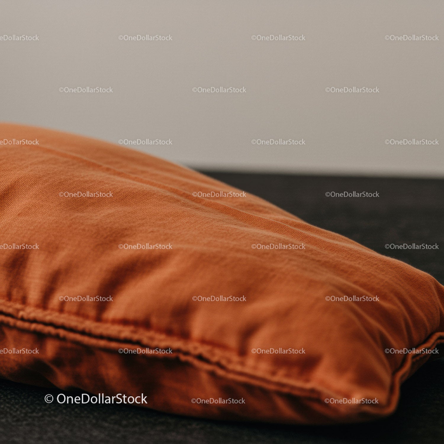 Close-up of Orange Fabric with Smooth Texture and Sewn Seam