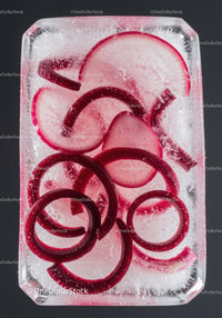 Red radish slices frozen in clear ice block