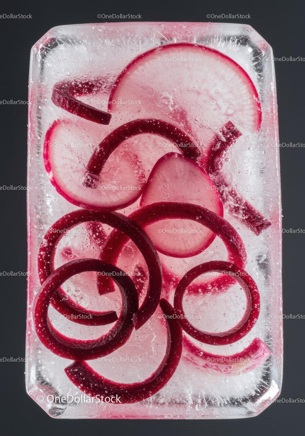 Red radish slices frozen in clear ice block