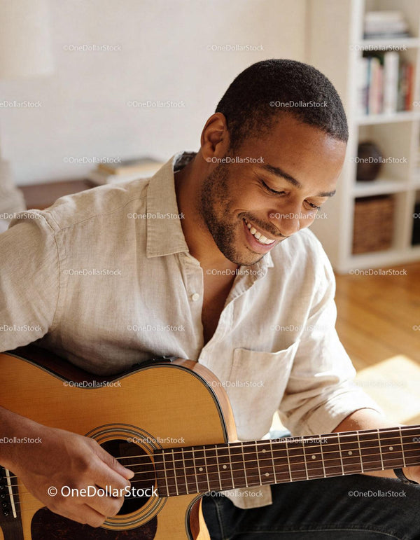 Smiling man enjoying playing acoustic guitar at home