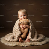 Cute toddler wrapped in cozy blanket hugging teddy bear