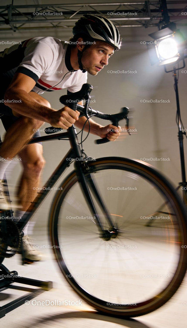 Focused Cyclist Training Indoors on Stationary Bike