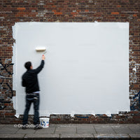 Man Painting Over Graffiti on Urban Brick Wall