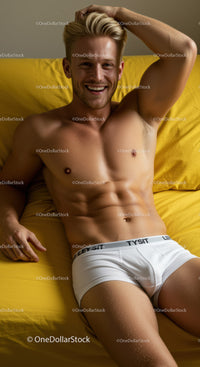 Smiling young man relaxing on yellow bed with white shorts