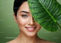 Close-Up of Young Woman with Bright Skin Behind Green Leaf