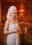 Young Woman Relaxing in Sauna with Towel Wrapped Around Her Body