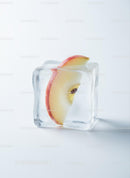 Fresh apple slice frozen inside a transparent ice cube
