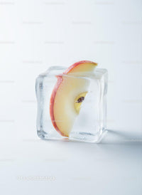 Fresh apple slice frozen inside a transparent ice cube