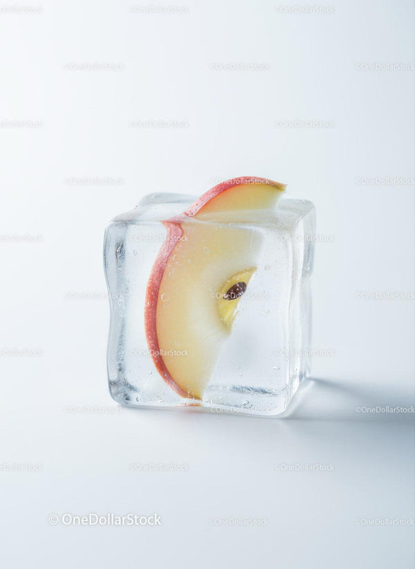 Fresh apple slice frozen inside a transparent ice cube
